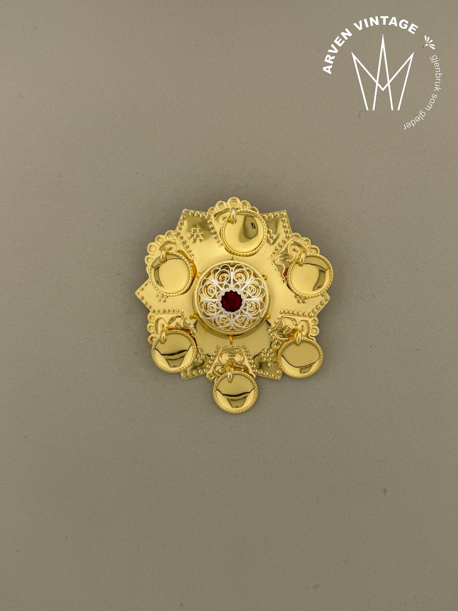 Vintage forgylt ansiktssølje med rød stein